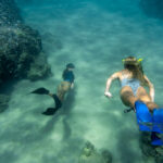 women-freediving-with-flippers-underwater